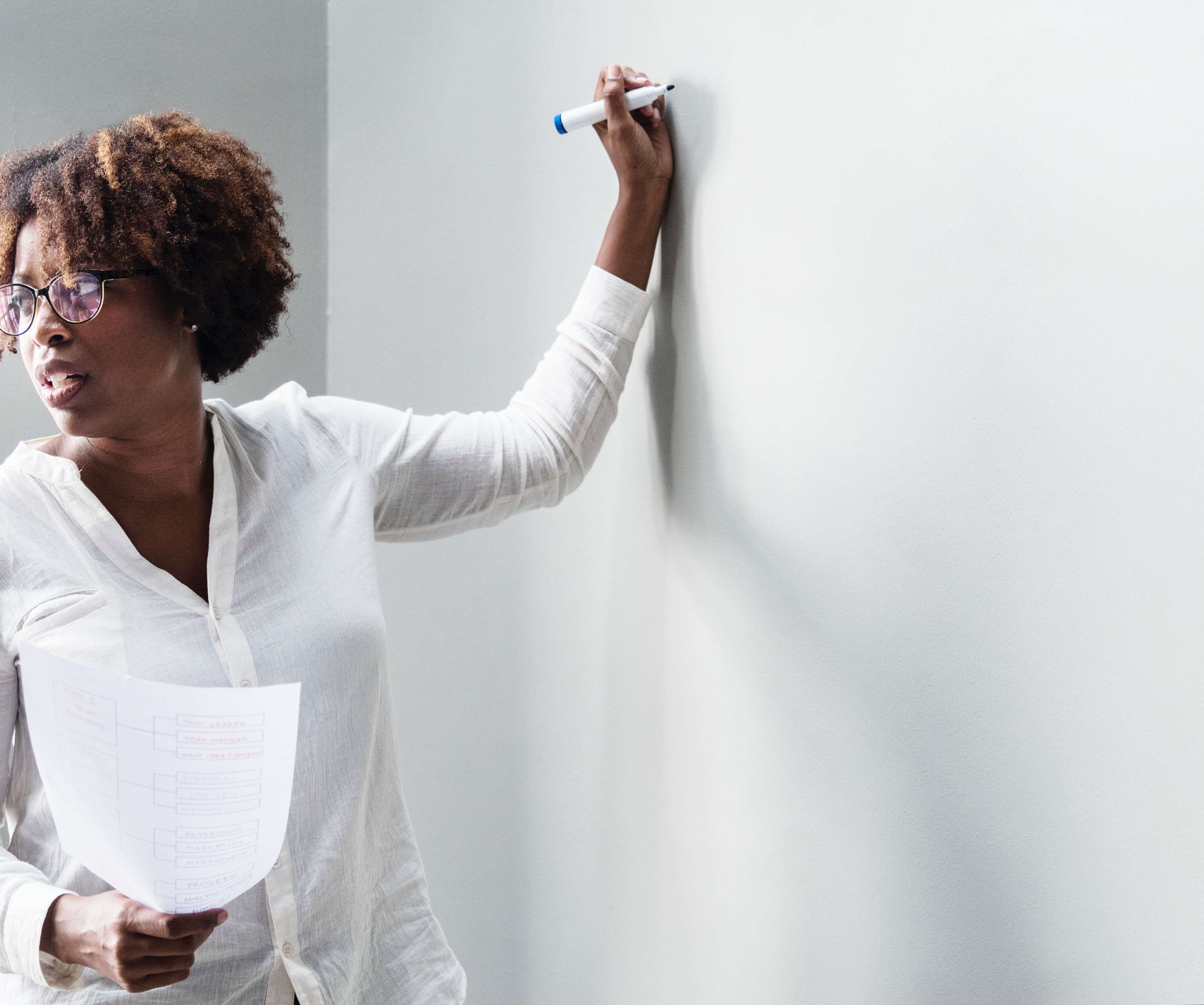 Teacher stands in front of white board Teacher role models civil behavior to nursing students in classroom