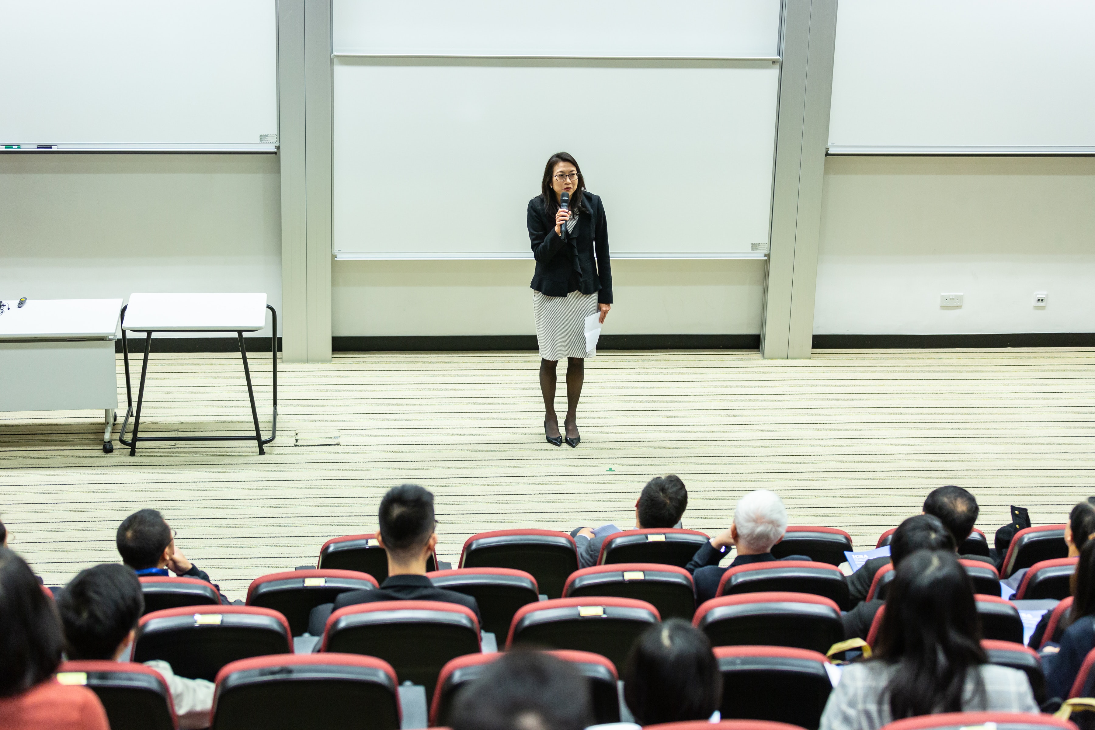 Female teacher stands in front of large class of students Female teacher is uncivil standing in front of class of nursing students