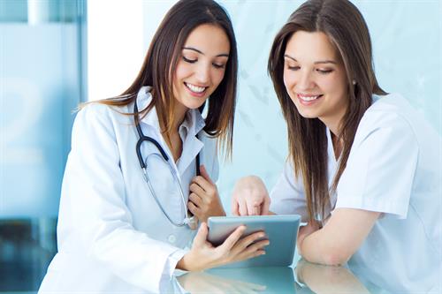 Two student nurses look at digital tablet