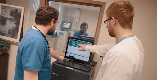 Nurses analyze cues to form a hypothesis. 2 nurses reviewing data on computer screen.