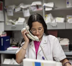 Woman looking at records and talking on phone.