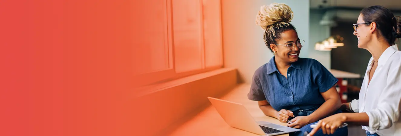 Two nurse educators talking over a laptop